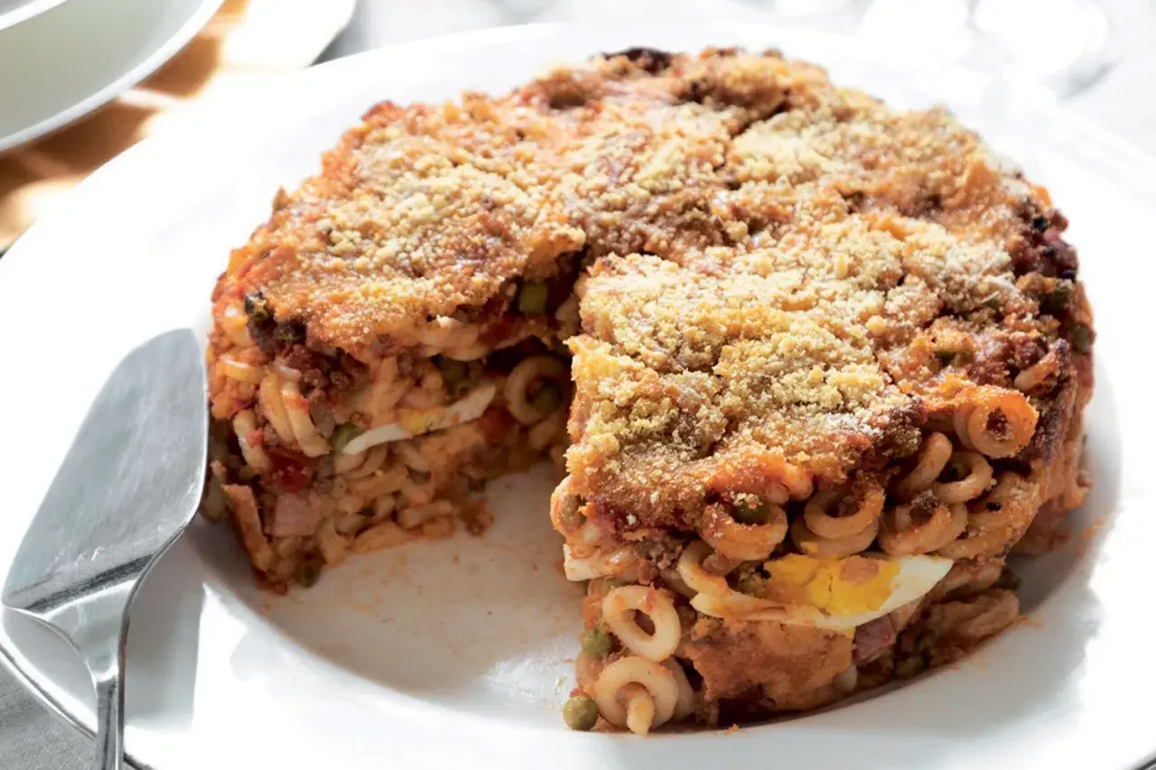 Un invitante anelletti al forno, stratificato con uova sode, piselli e ragù, con una croccante panatura dorata.