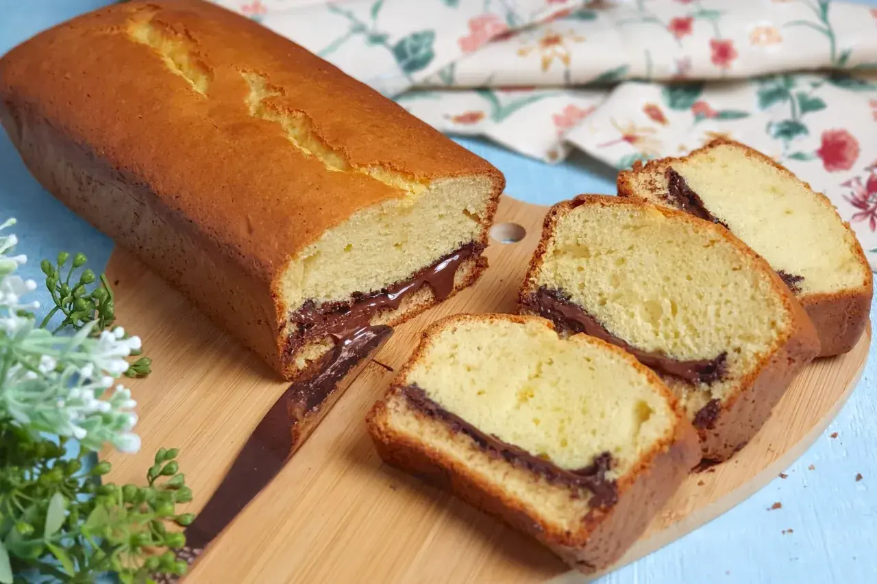 Plumcake soffice con cuore di cioccolato, perfetto per la tua ricetta. Fette golose su tagliere di legno.