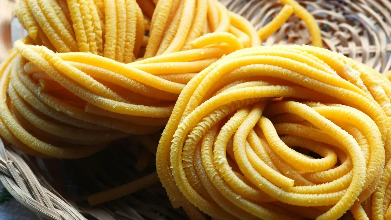 Pici all'aglione, pasta fresca fatta a mano, arrotolata in un cesto di vimini, pronta per essere gustata.