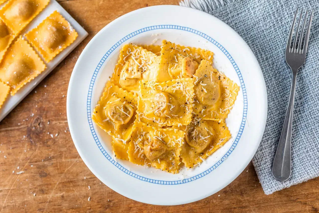 Tortelli di zucca ricetta originale, un piatto invitante con pasta fresca ripiena, condita con parmigiano e pepe nero.