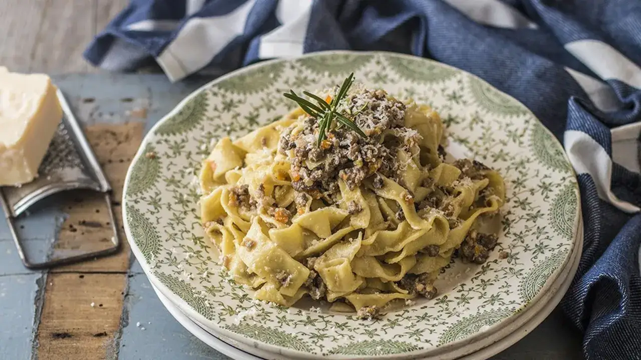 Tagliatelle condite con un saporito rag&ugrave; bianco, guarnite con rosmarino e parmigiano grattugiato.