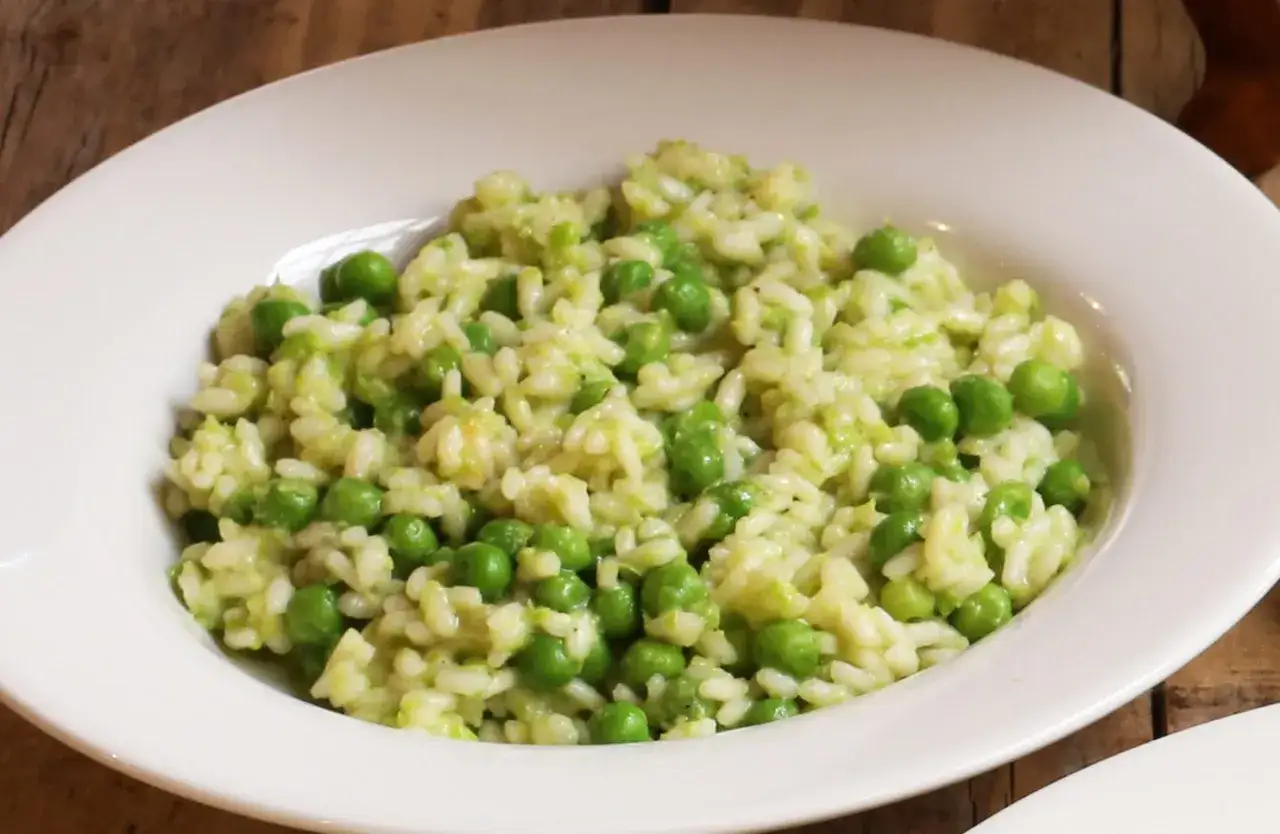 Un cremoso piatto di risi e bisi, con piselli freschi e riso carnaroli, pronto per essere gustato.