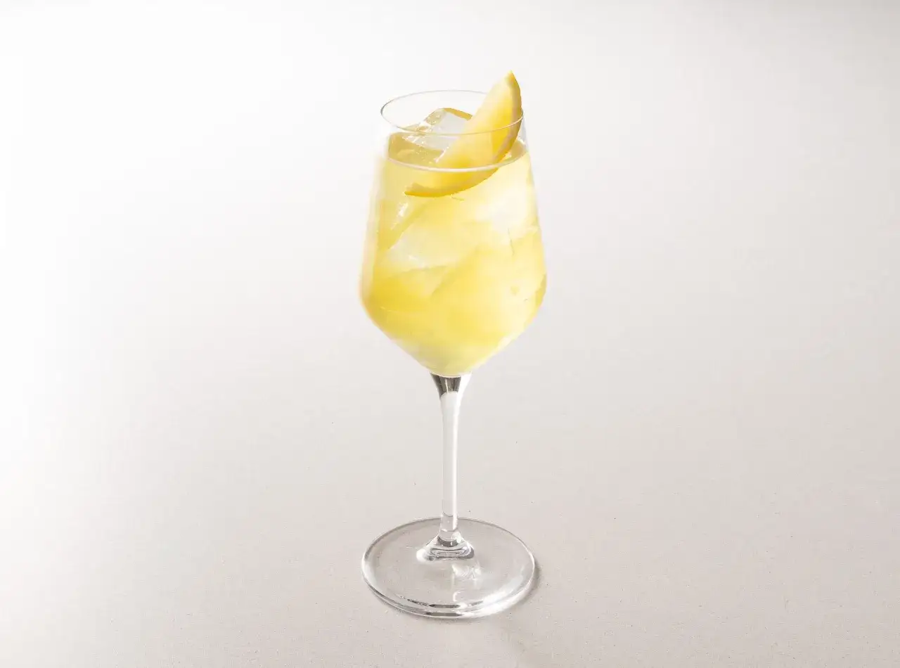 Un rinfrescante Amalfi Spritz, con ghiaccio e una fetta di limone, pronto per un aperitivo estivo.