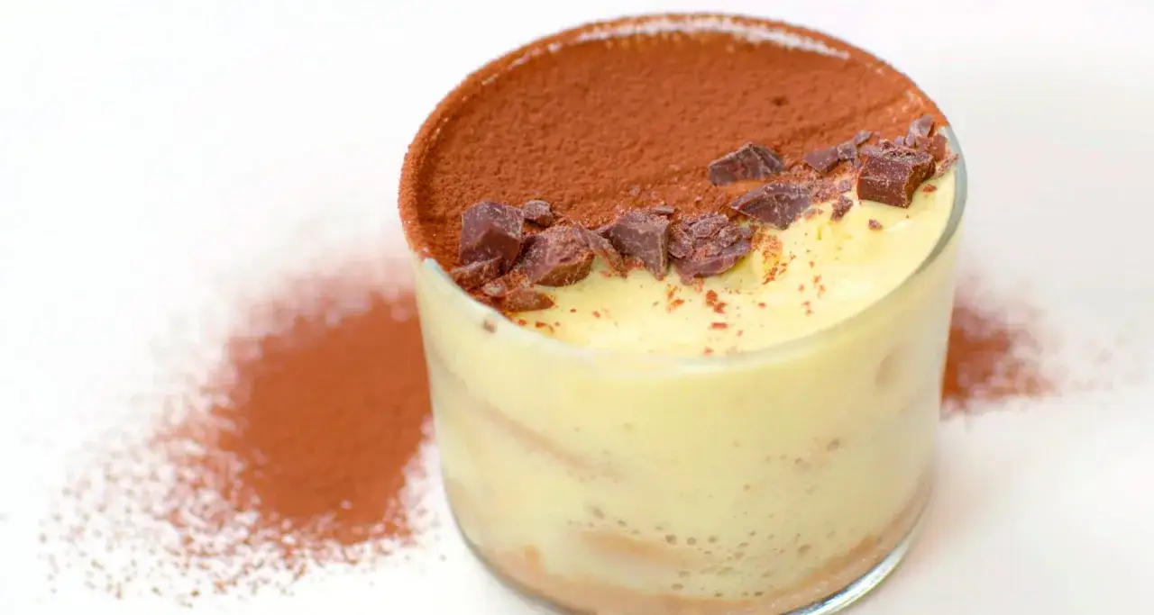 Delizioso tiramis&ugrave; in bicchiere, spolverato di cacao e scaglie di cioccolato. Una perfetta tiramis&ugrave; ricetta da gustare.