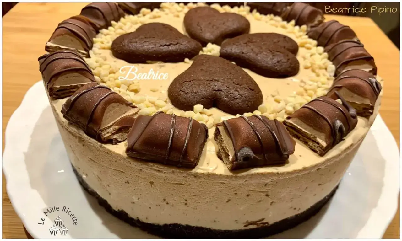 Torta gelato al caff&egrave;, decorata con biscotti a forma di cuore, nocciole e barrette di cioccolato.
