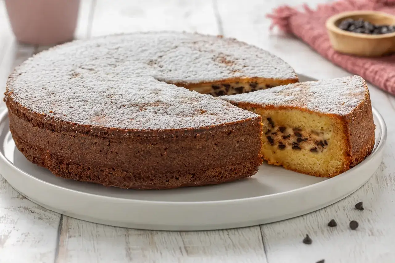 Torta soffice con ricotta e gocce di cioccolato, spolverata di zucchero a velo.