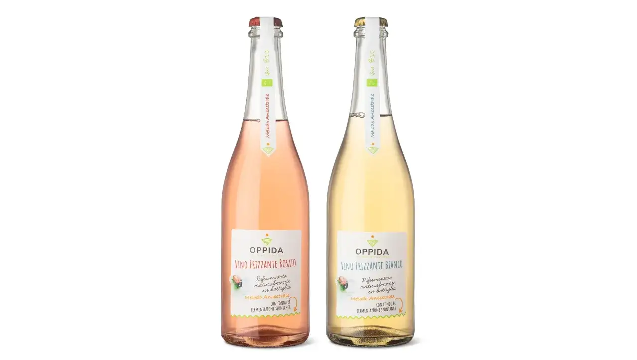 Due bottiglie di vino frizzante, rosato e bianco, con etichette che indicano 