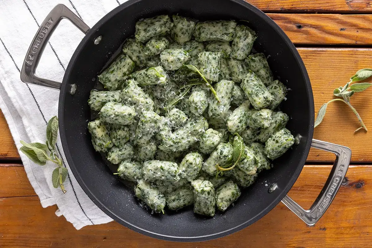 Strangolapreti alla trentina in padella, conditi con burro, salvia e parmigiano. Un piatto tradizionale che profuma di casa.