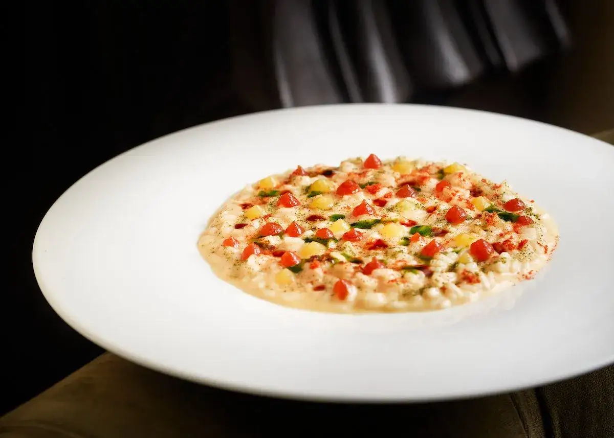 Risotto cremoso con pomodorini e verdure, perfetto per sauvignon blanc abbinamenti. Un piatto raffinato che esalta il vino.