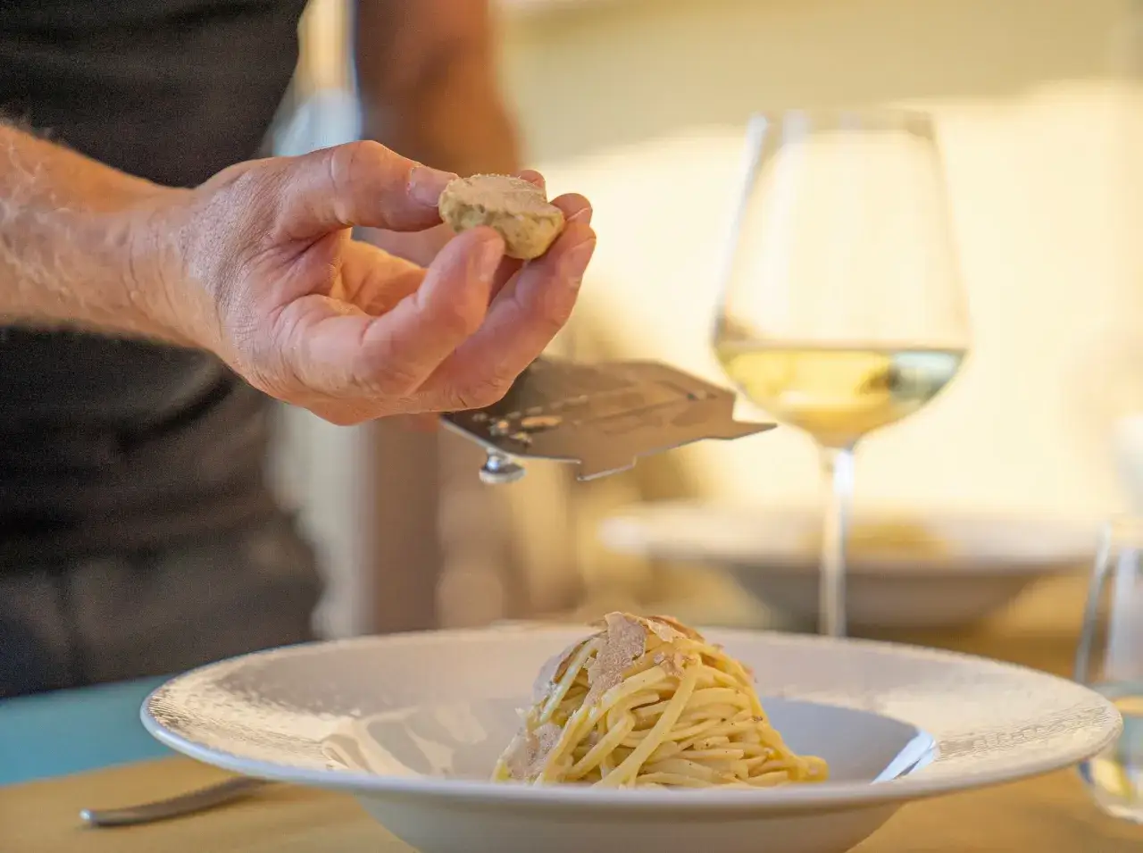 Un perfetto abbinamento vino tartufo: pasta fumante con scaglie di tartufo fresco e un calice di bianco.