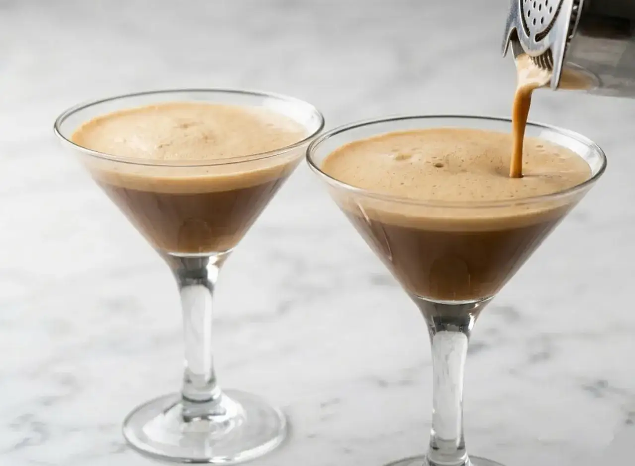 Due bicchieri di caff&egrave; shakerato con schiuma cremosa, uno viene riempito da uno shaker.