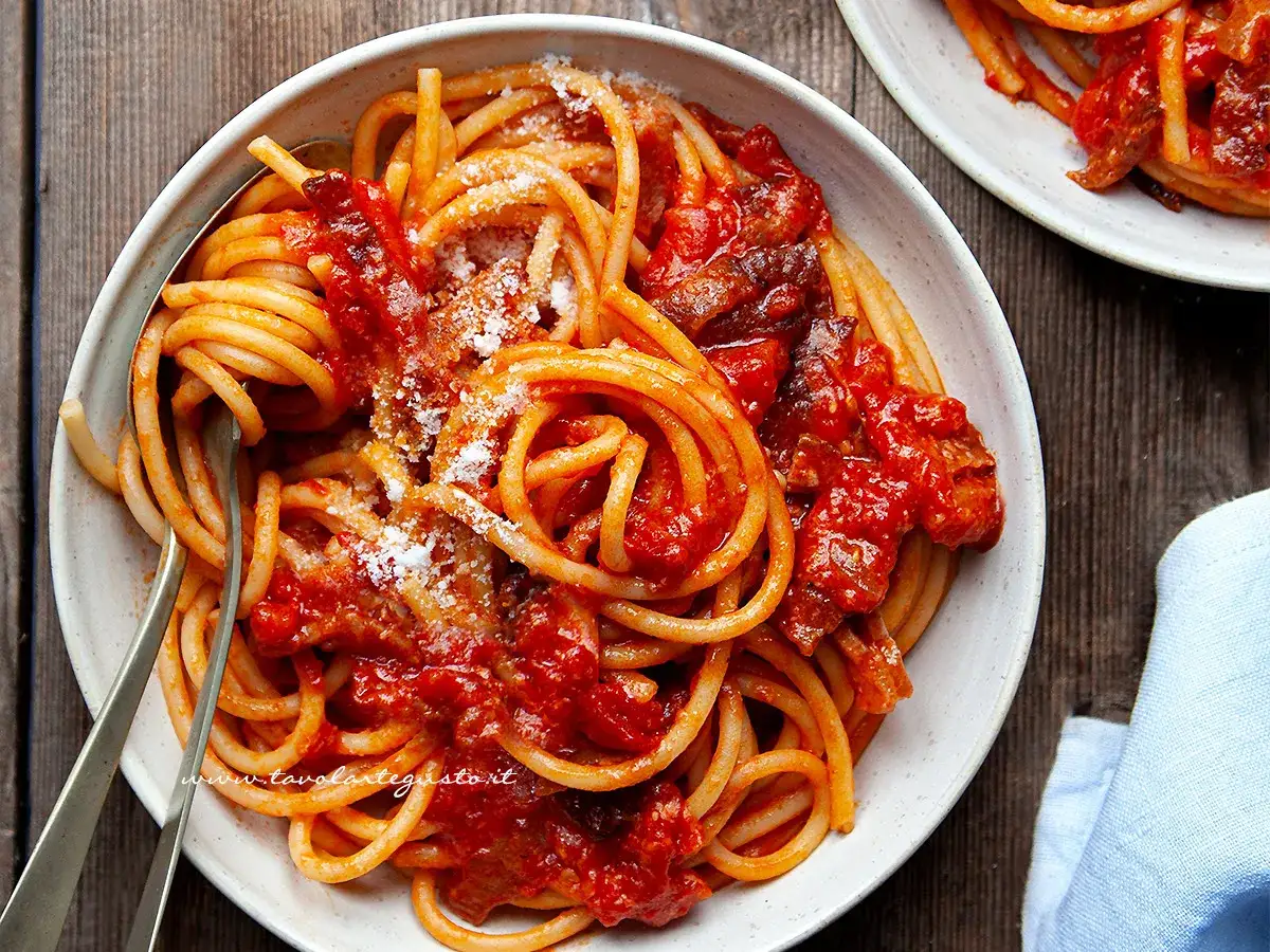 Bucatini all'amatriciana, un classico piatto romano. Perfetto con un vino rosso corposo per un abbinamento vino ideale.