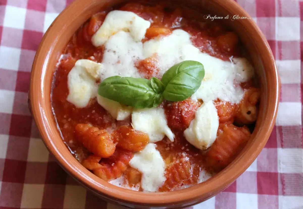 Gnocchi alla sorrentina fumanti in terracotta, con mozzarella filante e basilico fresco. Un piatto che profuma di casa.